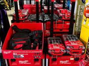 Milwaukee tool display with red toolboxes, batteries, and bags on store shelves
