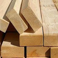 Stacked cut wooden boards with visible grain and light tan color
