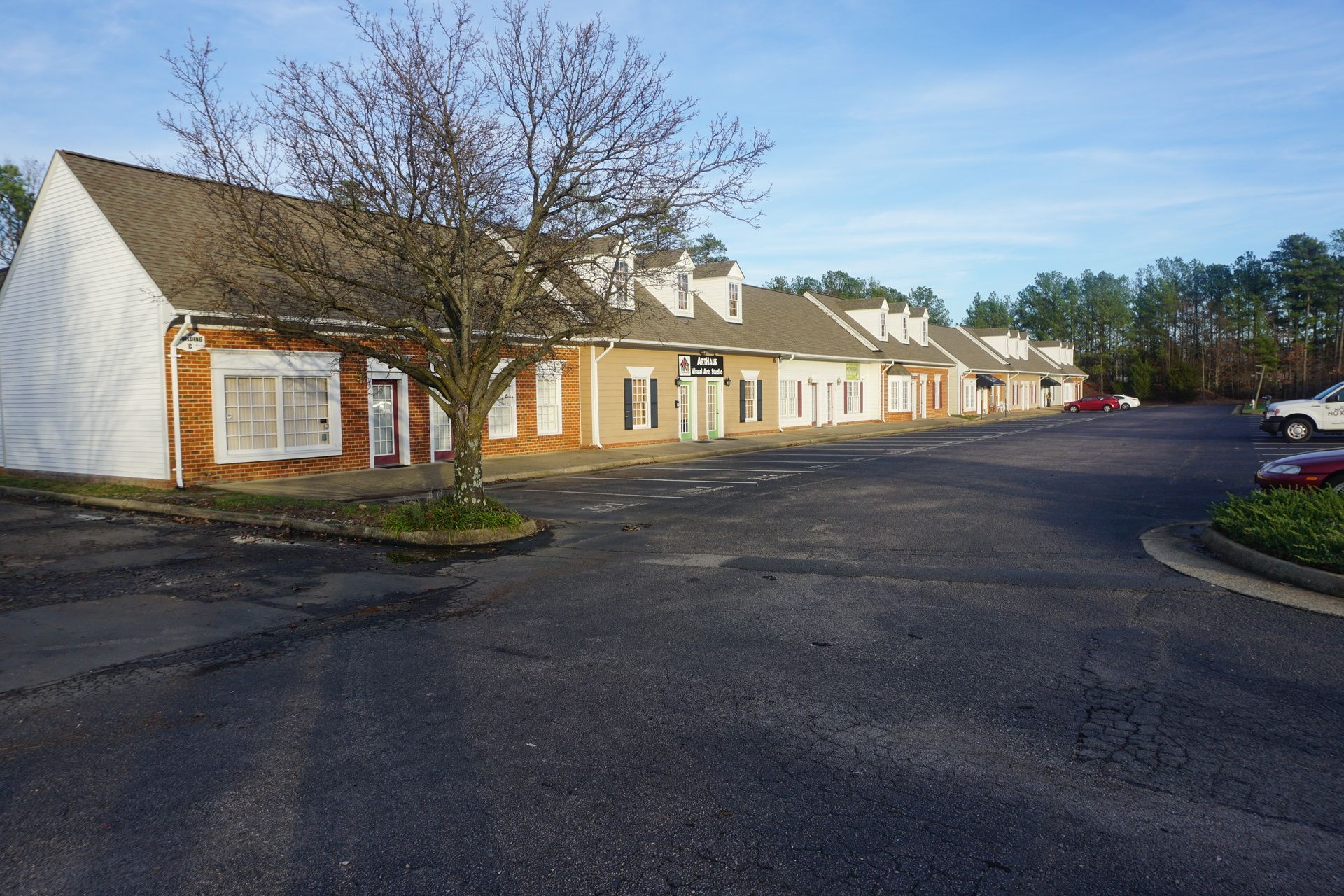 A row of buildings with cars parked in front of them.