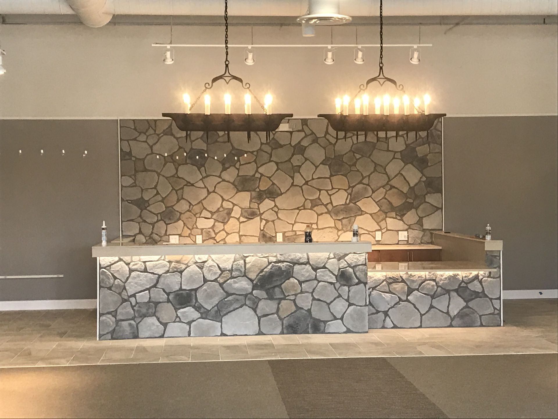 An empty room with a stone wall and a bar.
