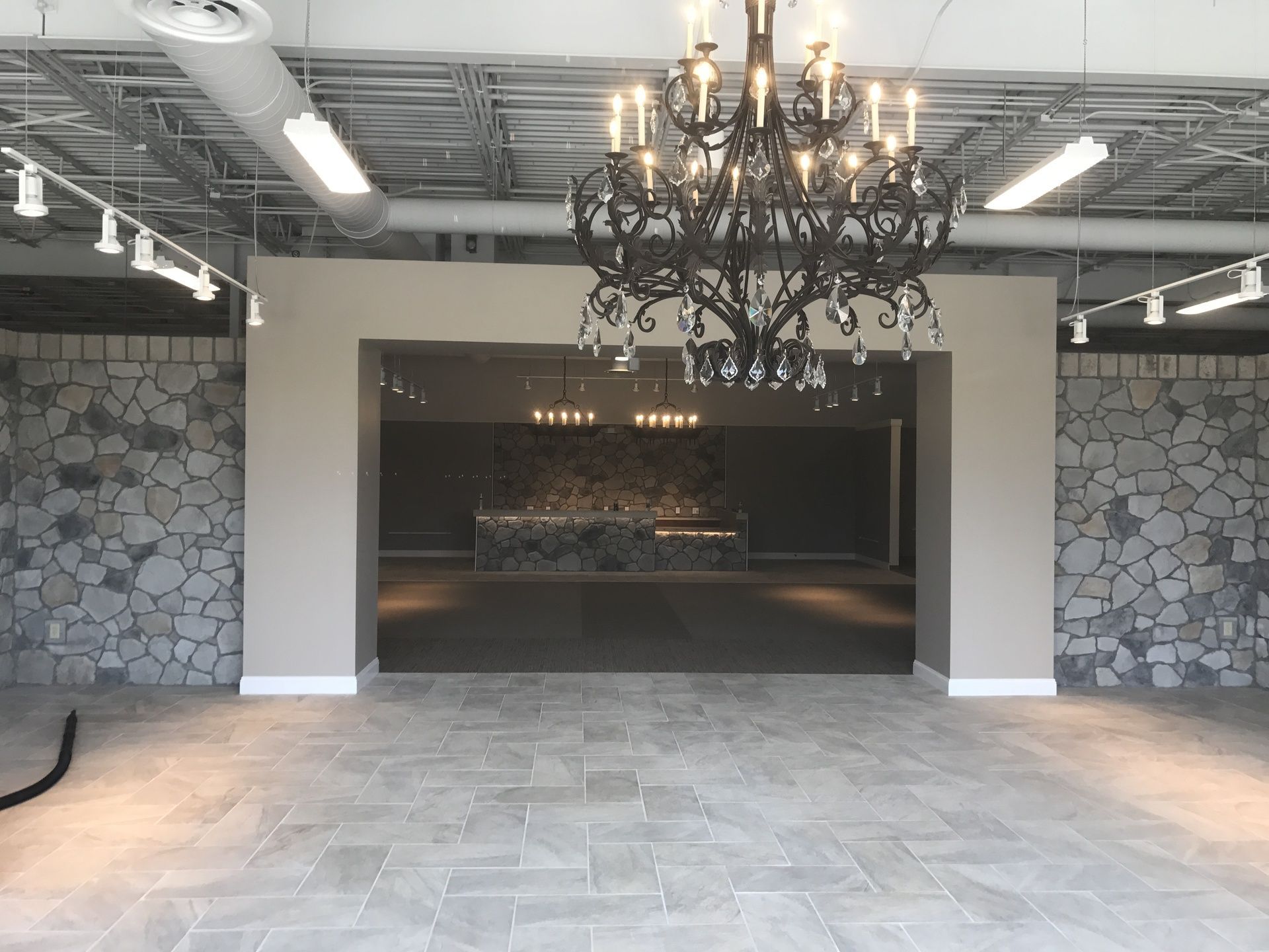 An empty room with a chandelier hanging from the ceiling