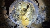 Rusty metal pipe interior with corroded yellow-brown buildup and dark circular opening