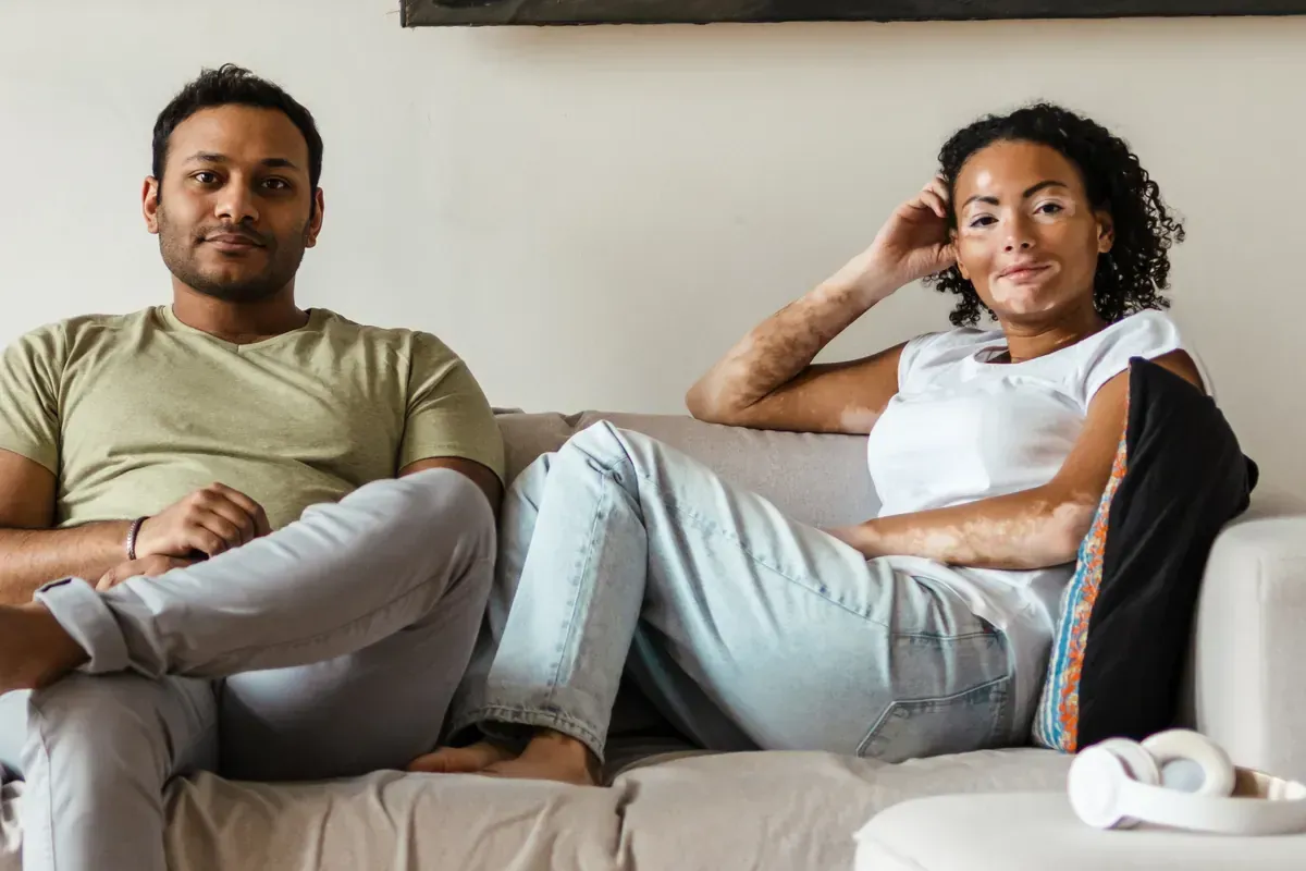 Couple sitting apart on a couch at home in Brampton, Ontario