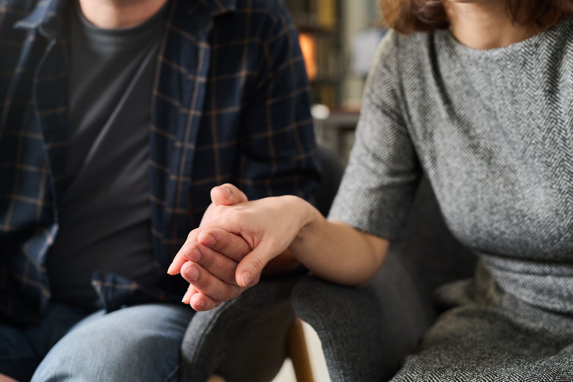 Couple holding hands during a therapy session focused on rebuilding trust after infidelity
