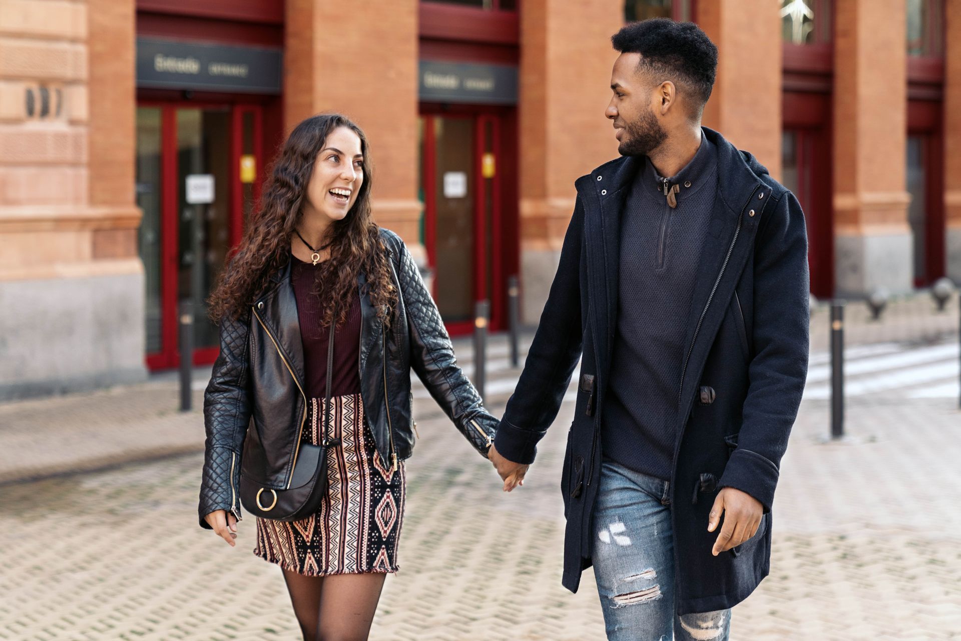 A woman and a man holding hands and smiling.