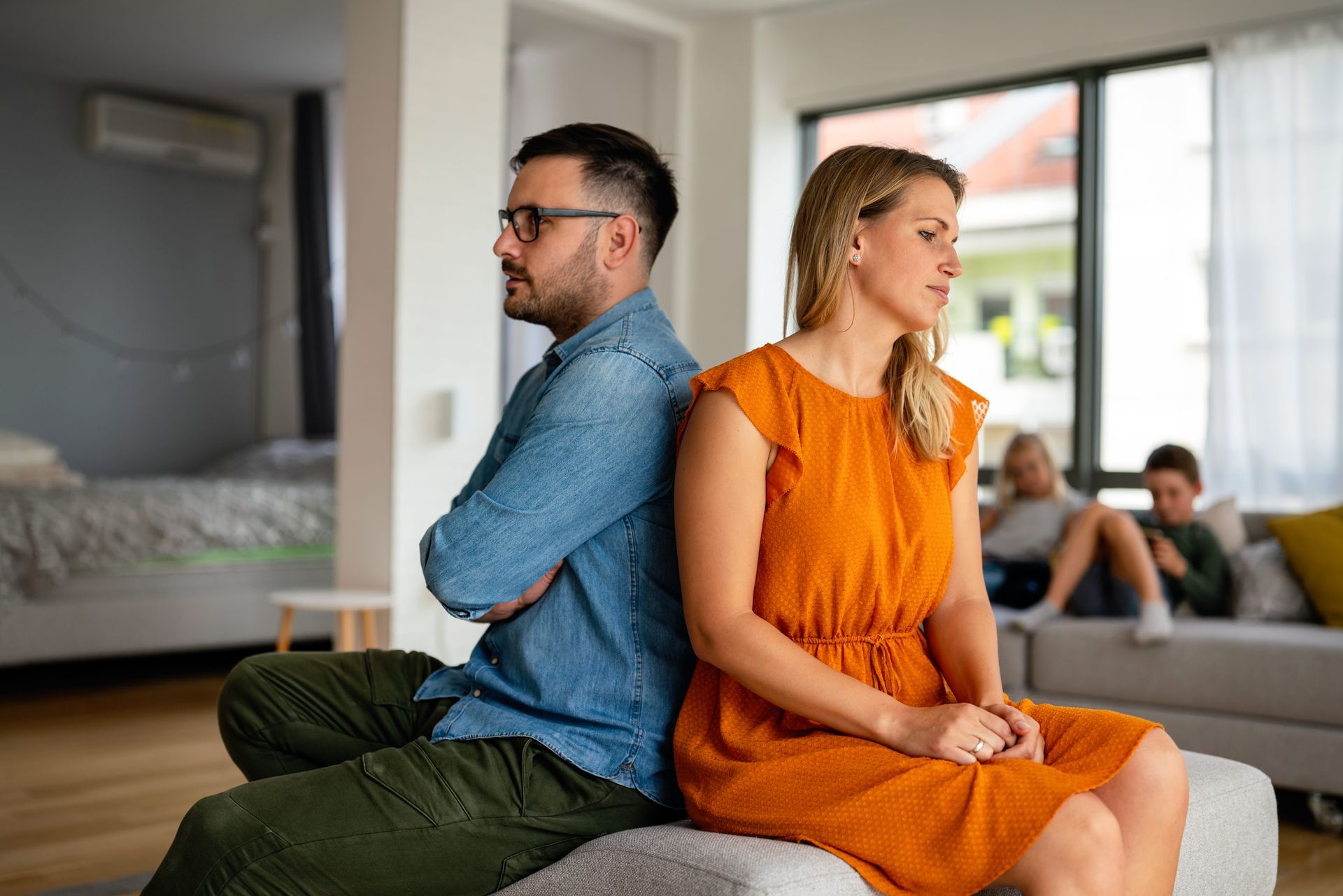A coupl sitting apart looking distant, illustrating early warning signs a marriage may be in trouble