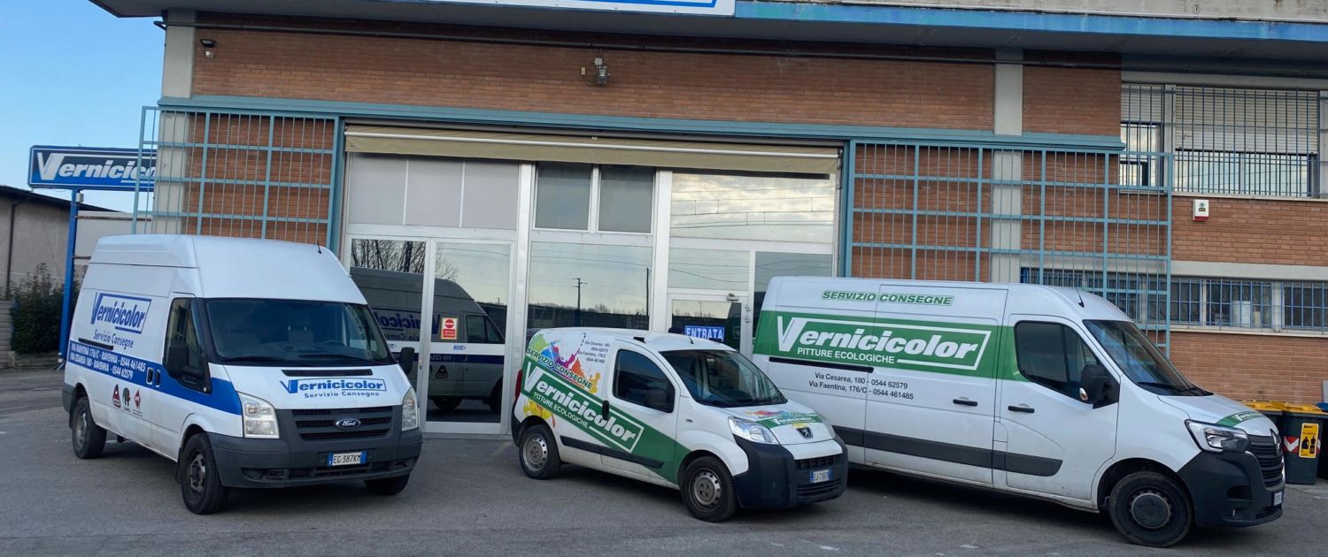 In una giornata limpida, tre furgoni aziendali erano parcheggiati davanti a un edificio commerciale in mattoni.