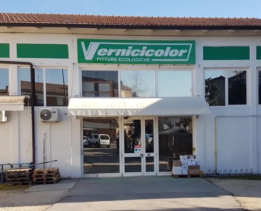 Un edificio bianco con un'insegna verde con la scritta 