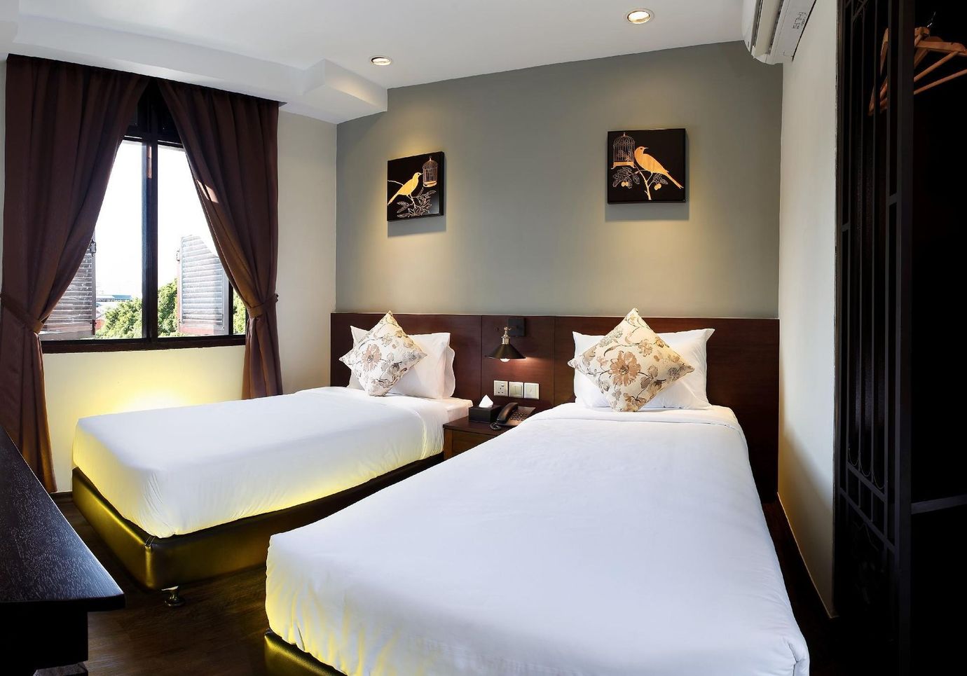A hotel room with two beds and a window