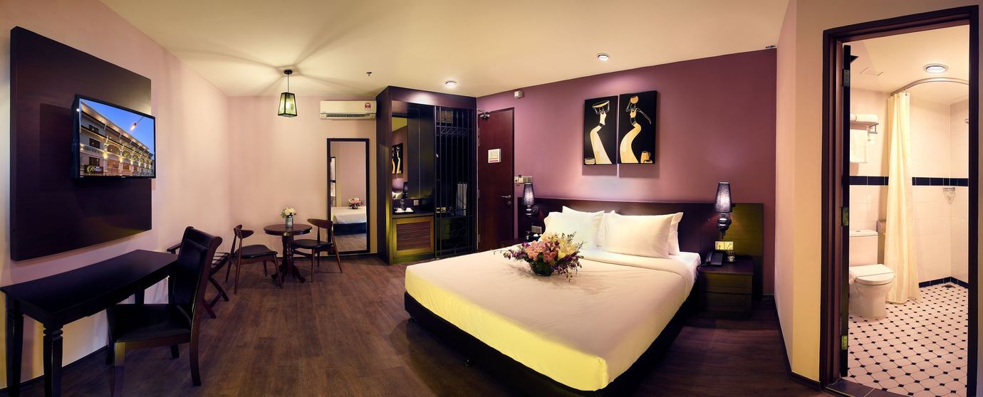 A hotel room with a king size bed and a flat screen tv.
