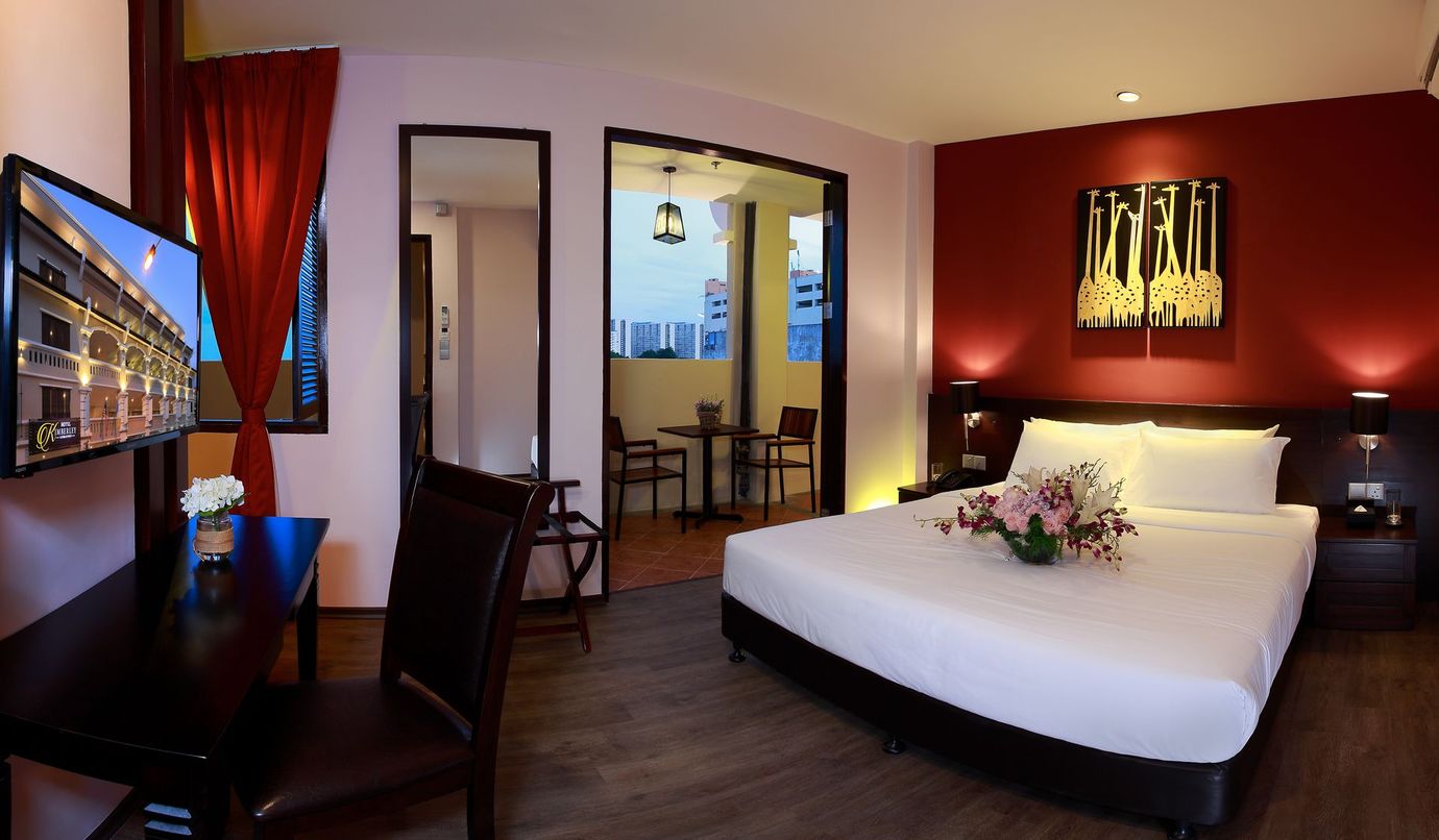 A hotel room with a king size bed and a flat screen tv