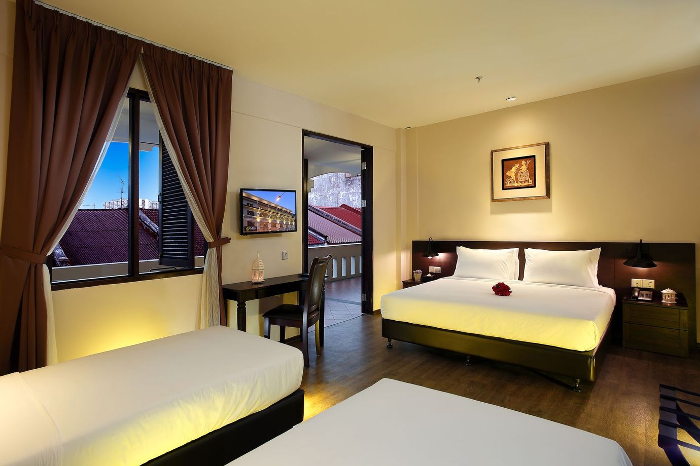 A hotel room with two beds , a desk and a television.