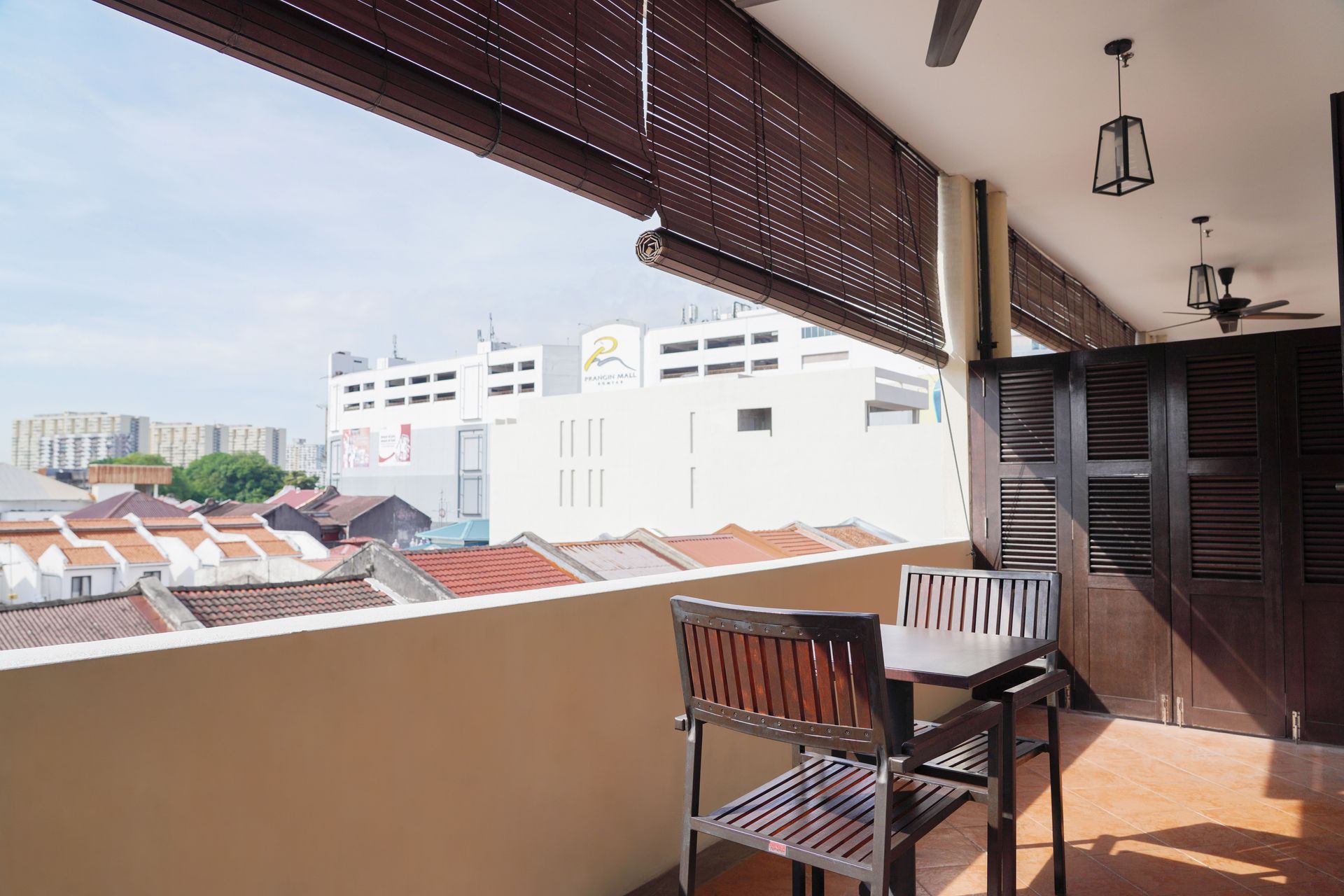 A balcony with a table and chairs overlooking a city