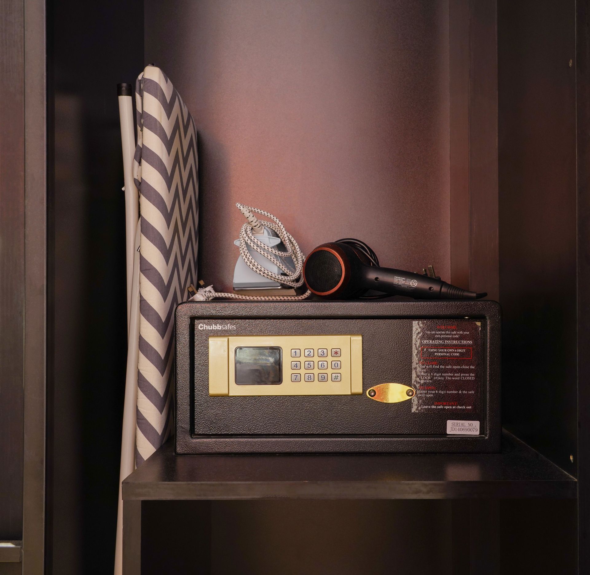 A safe in a closet with a hair dryer on top of it