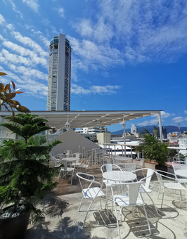 Tables and chairs on a rooftop with a city in the background