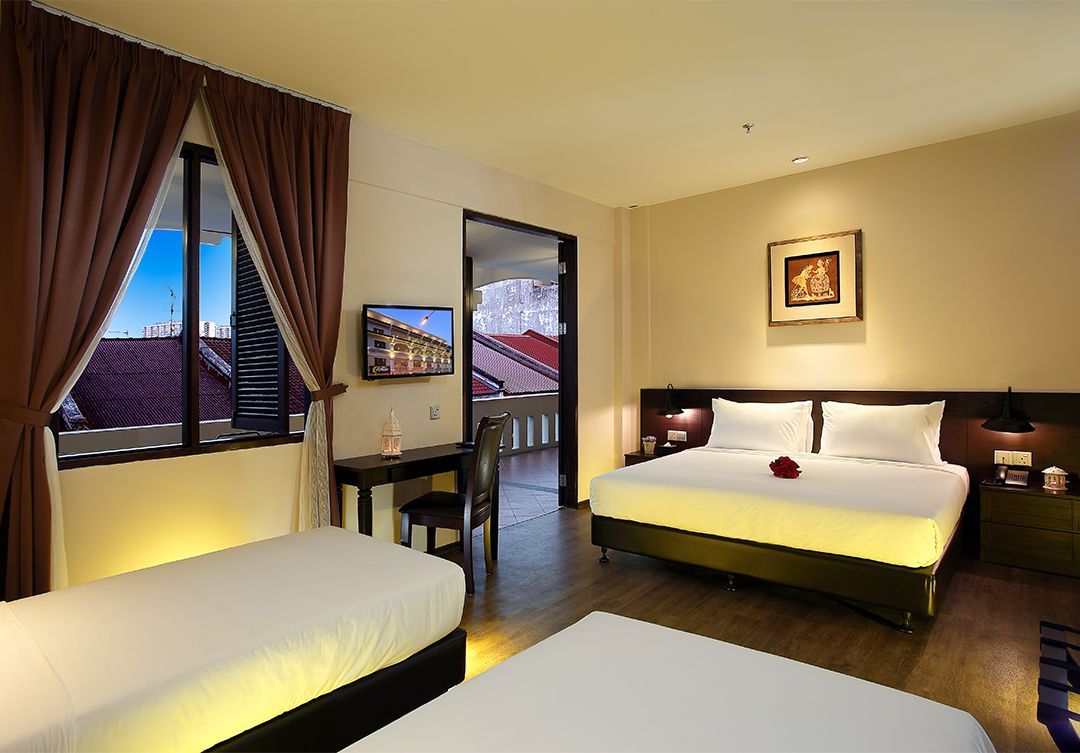 A hotel room with two beds , a desk and a television.