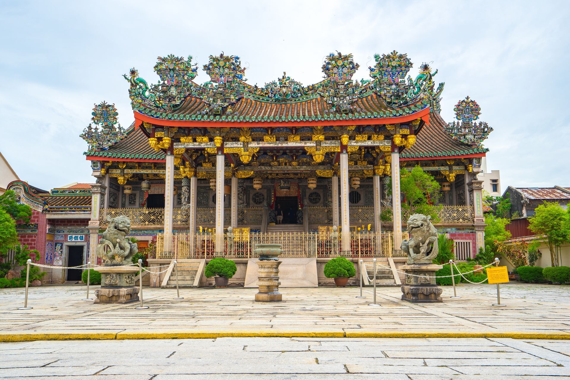 A large chinese temple with a red roof and columns.