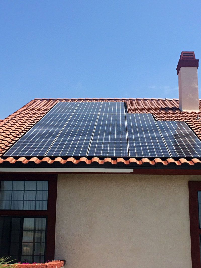 House roof with solar panels under a blue sky