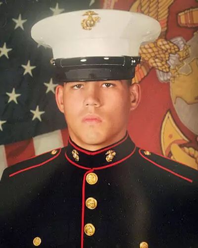 Portrait of a Marine in dress uniform before an American flag backdrop | Strother Brothers Auto Care