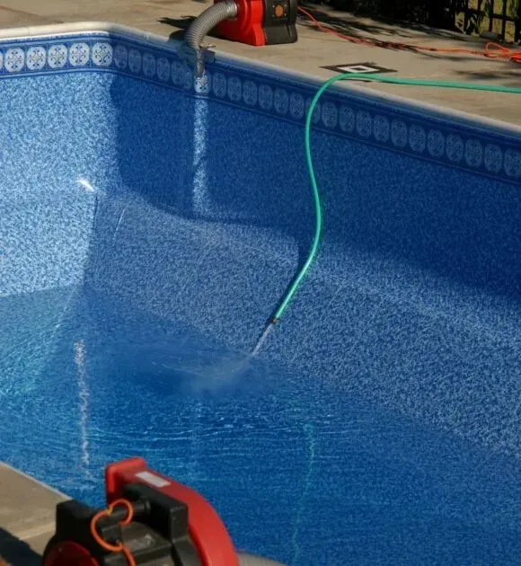 A hose is filling a swimming pool
