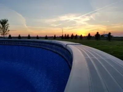 an evening photo of an above ground pool's edge