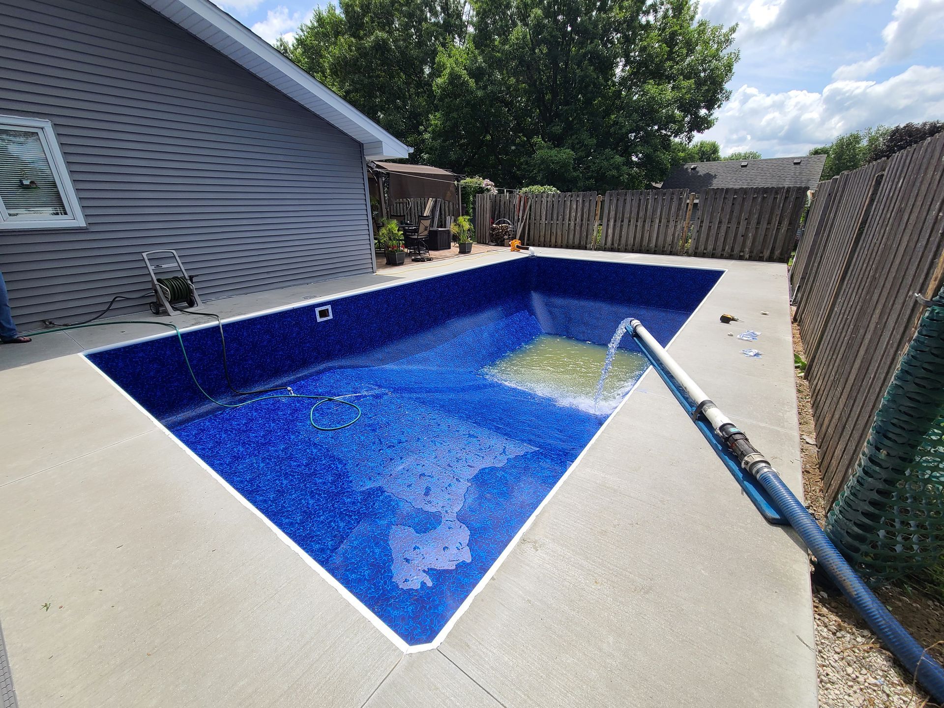 a brand new in ground pool being filled