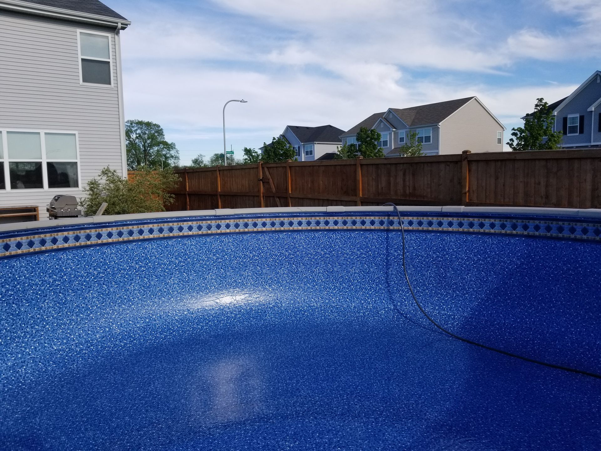 A blue net is being used to clean a swimming pool.