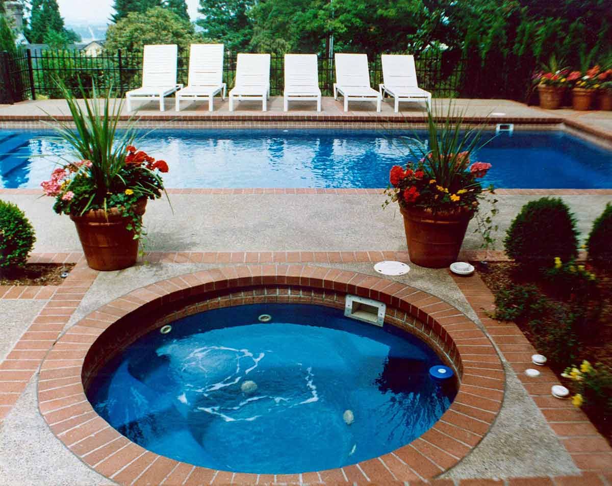 an in ground hot tub with clear blue water