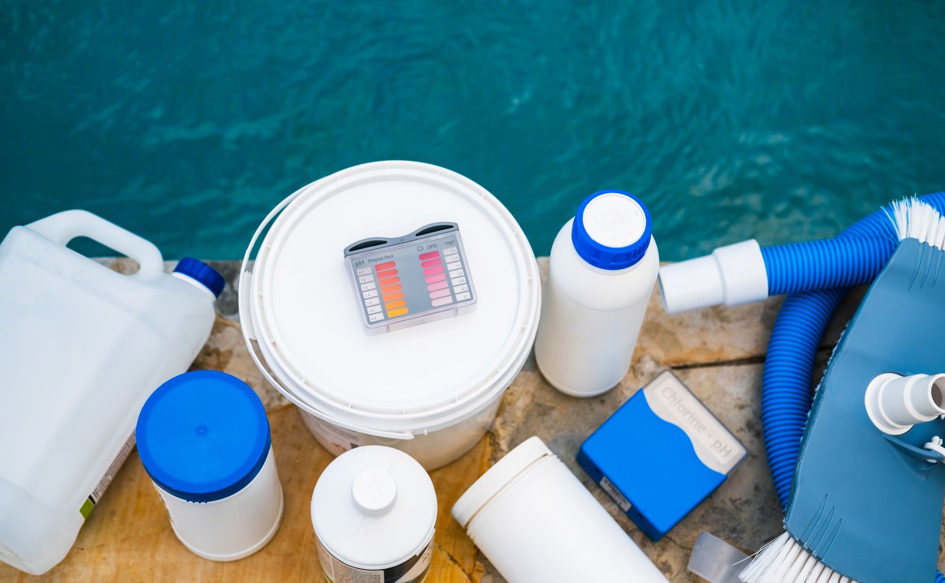 A bunch of pool supplies are sitting next to a pool.