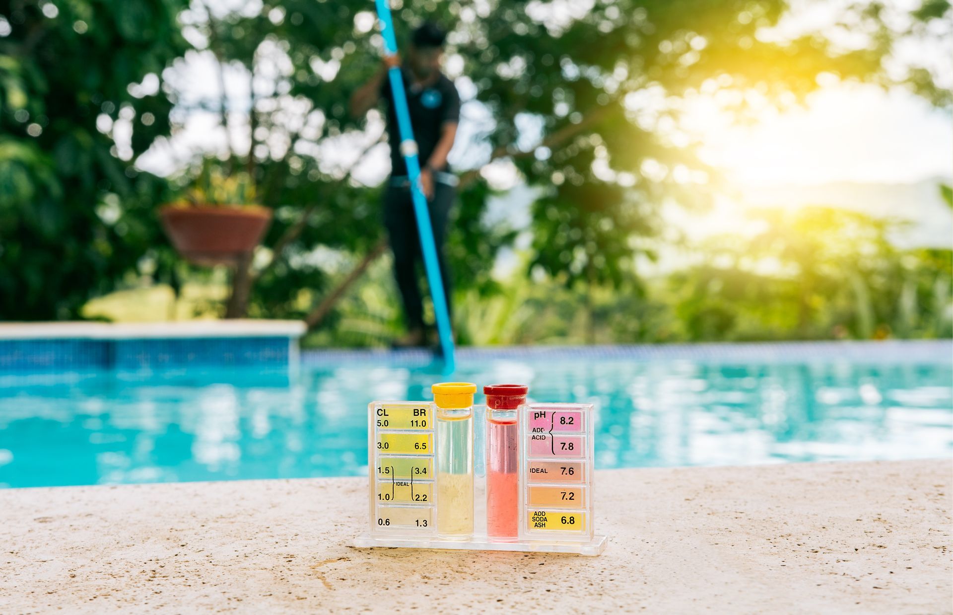 A man is cleaning a swimming pool with a skimmer