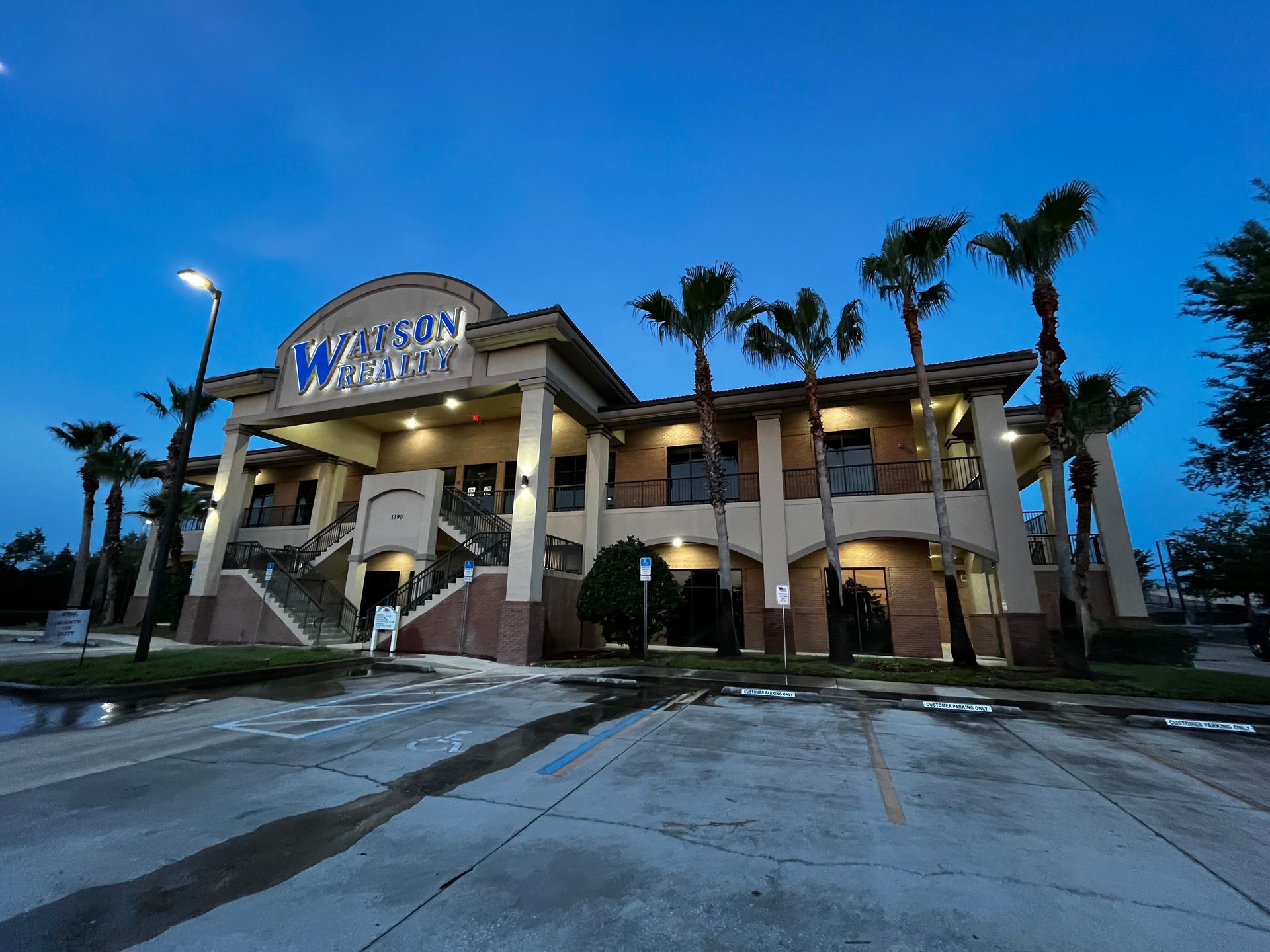 Westwood Apartments building at dusk with palm trees and lit entrance