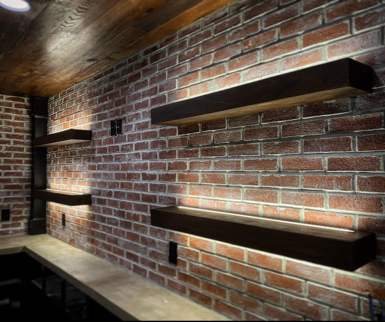 A room with a brick wall and shelves on it