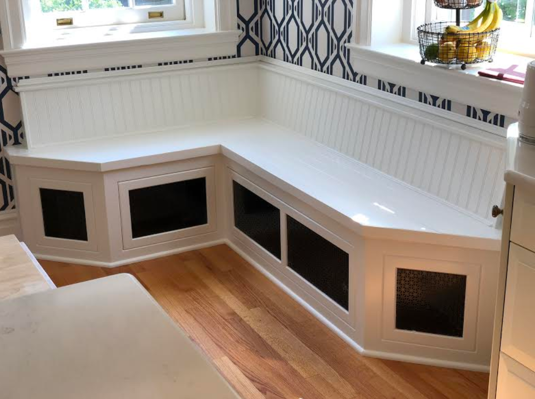 a kitchen with a corner bench and a window .