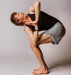 A man is squatting down in a yoga pose.