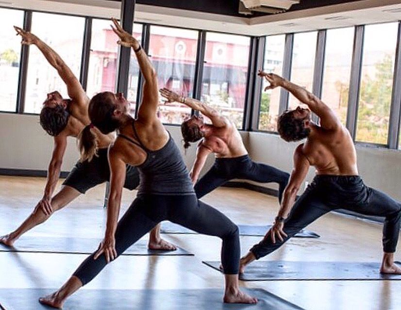 A group of people are practicing yoga in a gym.