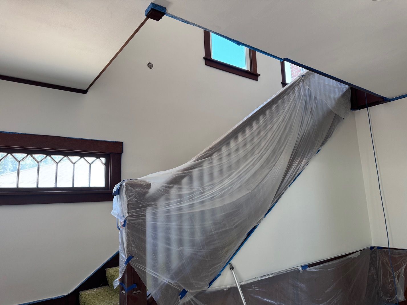 Large white room with a slanted gray canopy or netting draped from the ceiling.