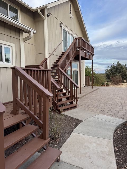 Exterior stairs and ramp beside a tan building, with a paved walkway and desert landscaping.