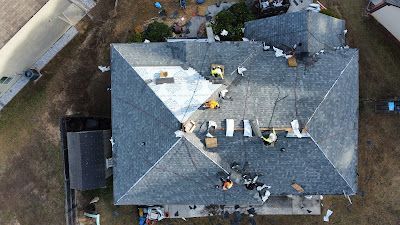 An aerial view of a house with a roof being repaired.