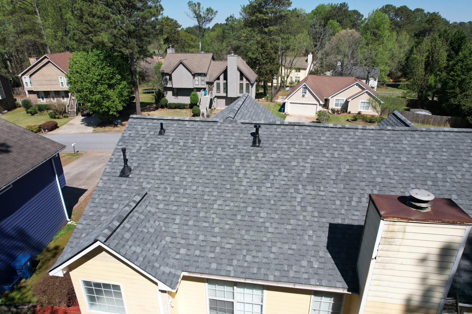 An aerial view of a roof of a house in a residential area.