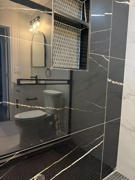 A bathroom with a sliding glass shower door and a blue rug.