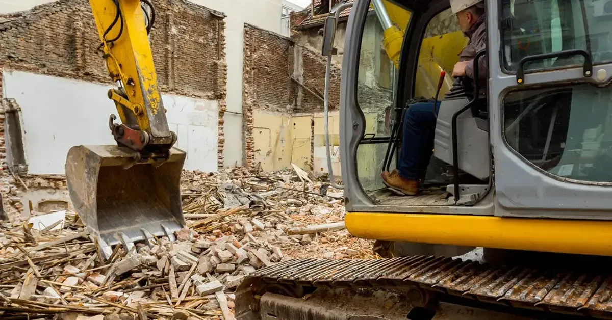 excavator operator clearing demolition debris on a Central Texas property