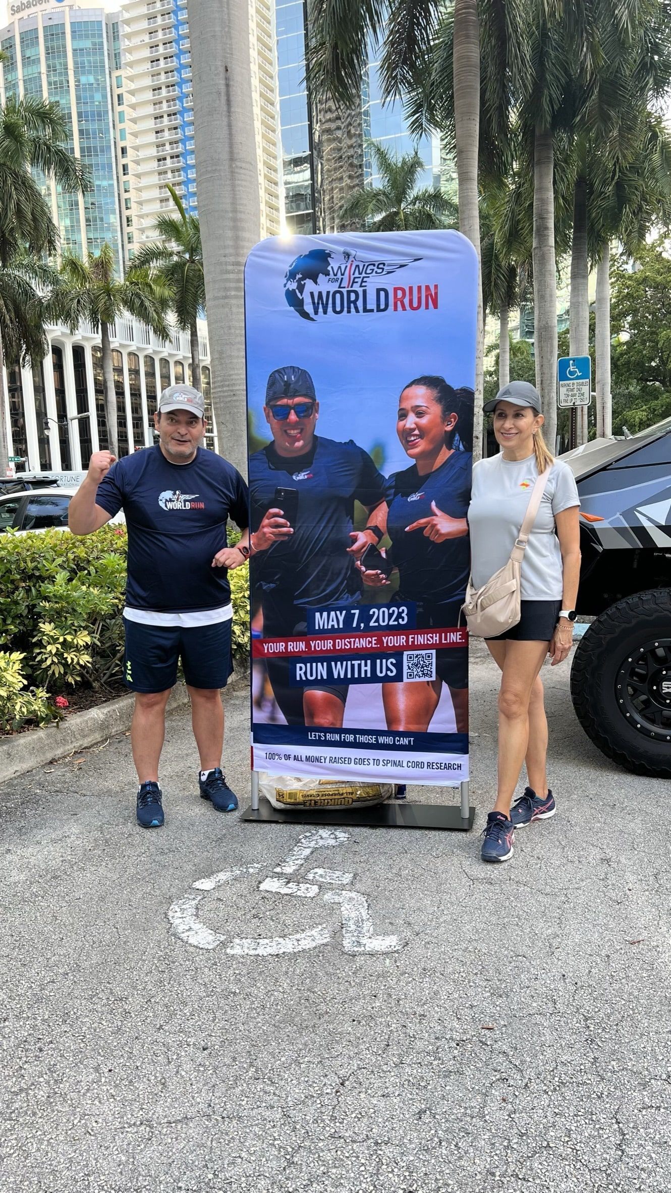 A man and a woman are standing next to a large banner.