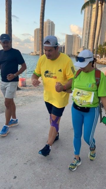 A man in a yellow shirt is walking with two other people