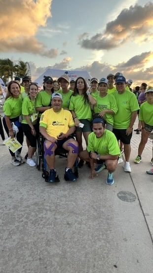 A group of people wearing green shirts are posing for a picture.