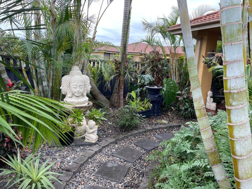 An Outdoor Garden With Plants and Statues — Greener Gardens Gardening Service In Thrumster, NSW