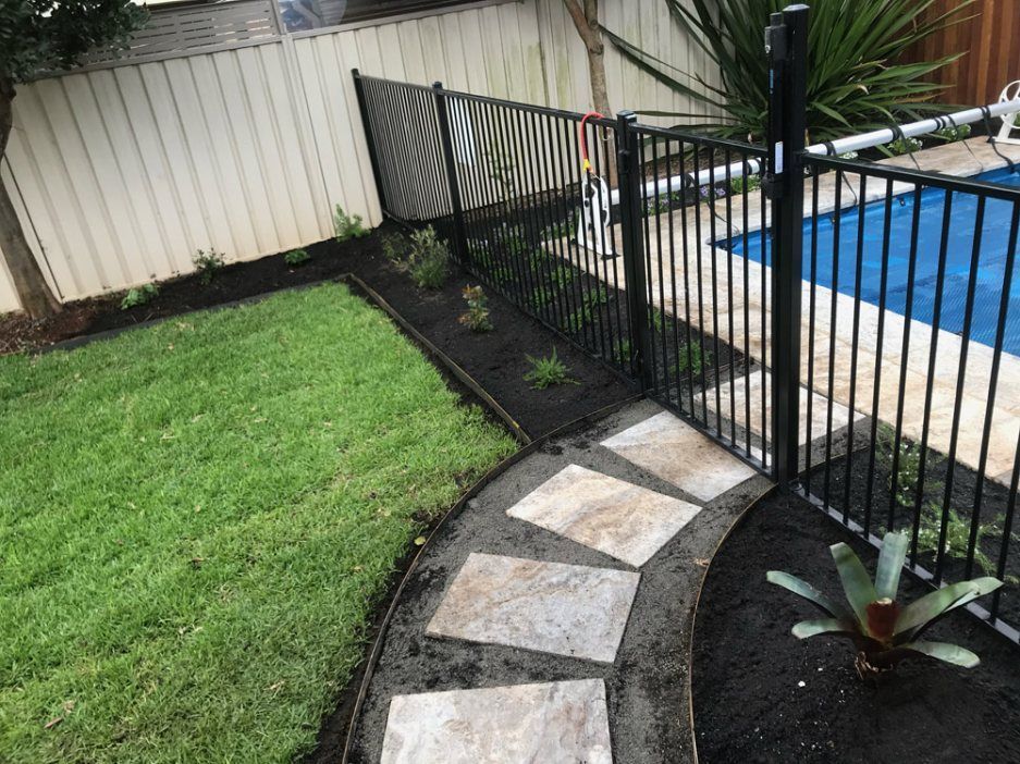 A Fence Surrounds a Swimming Pool in a Backyard — Greener Gardens Gardening Service In Thrumster, NSW