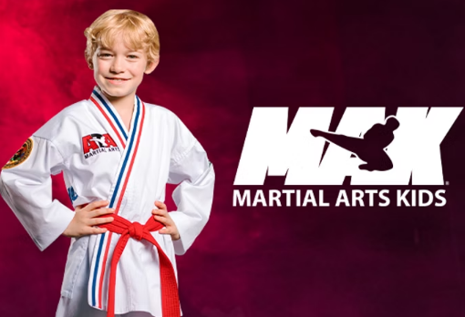 Blond child in martial arts uniform with red belt, smiling at the camera, next to the MAX Martial Arts Kids logo.