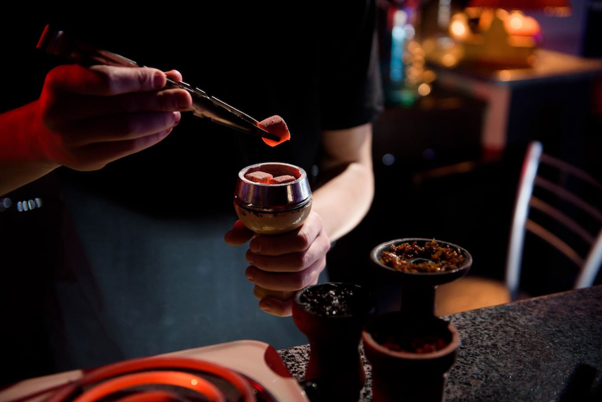 Holding A Hookah Bowl With Red Hot Coals — Mini Market Townsville Smoke Shop in Townsville City, QLD