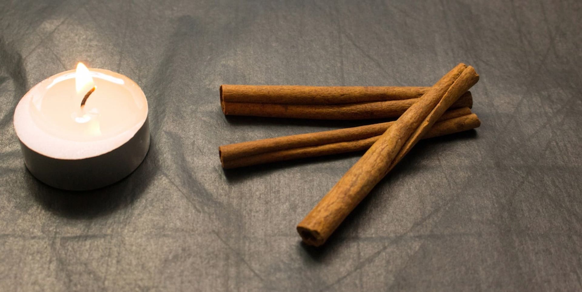 Cinnamon Sticks and A Lit Candle on A Table — Mini Market Townsville Smoke Shop in Townsville City, QLD