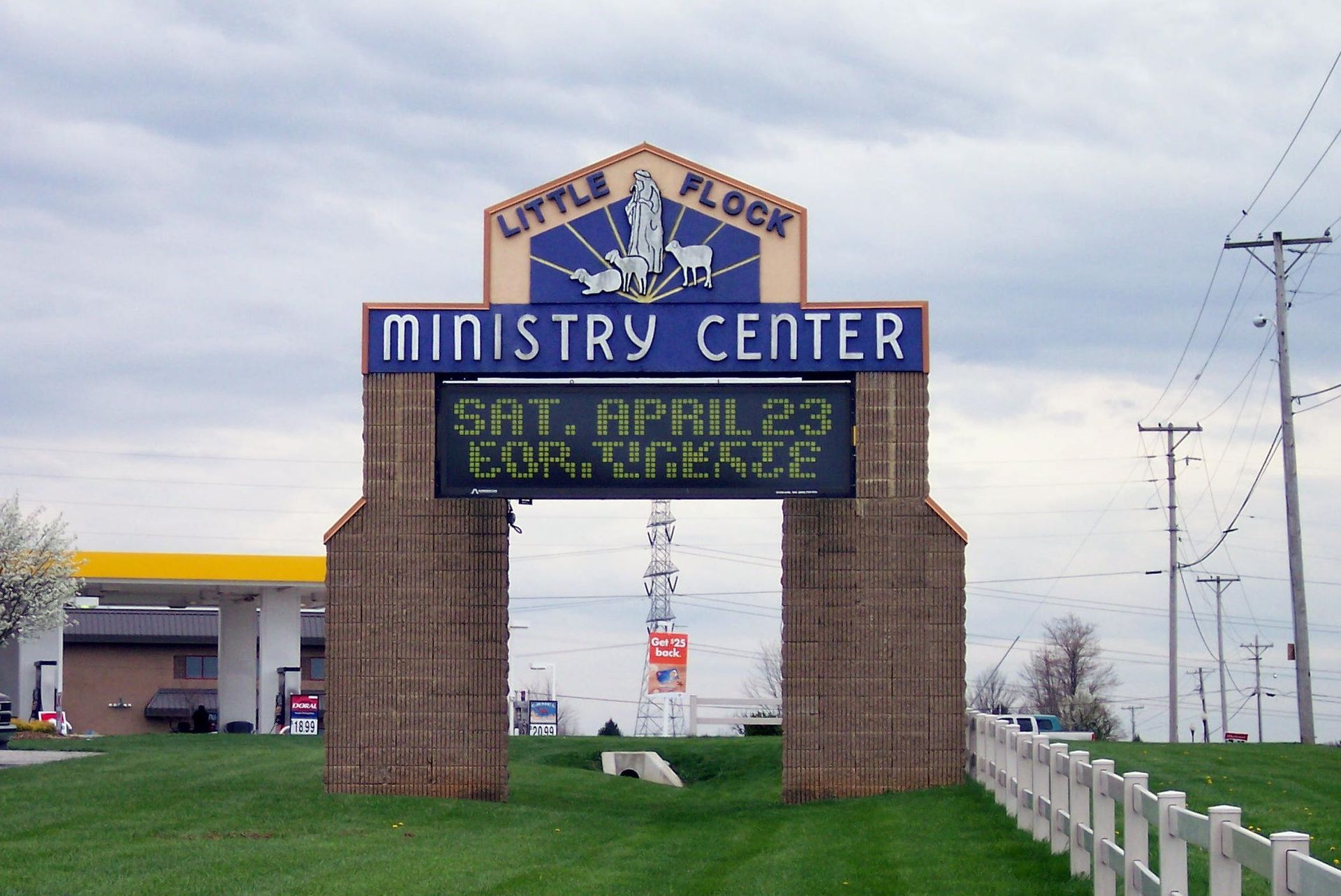 Roadside sign for the Ministry Center with blue digital message board under an overcast sky.